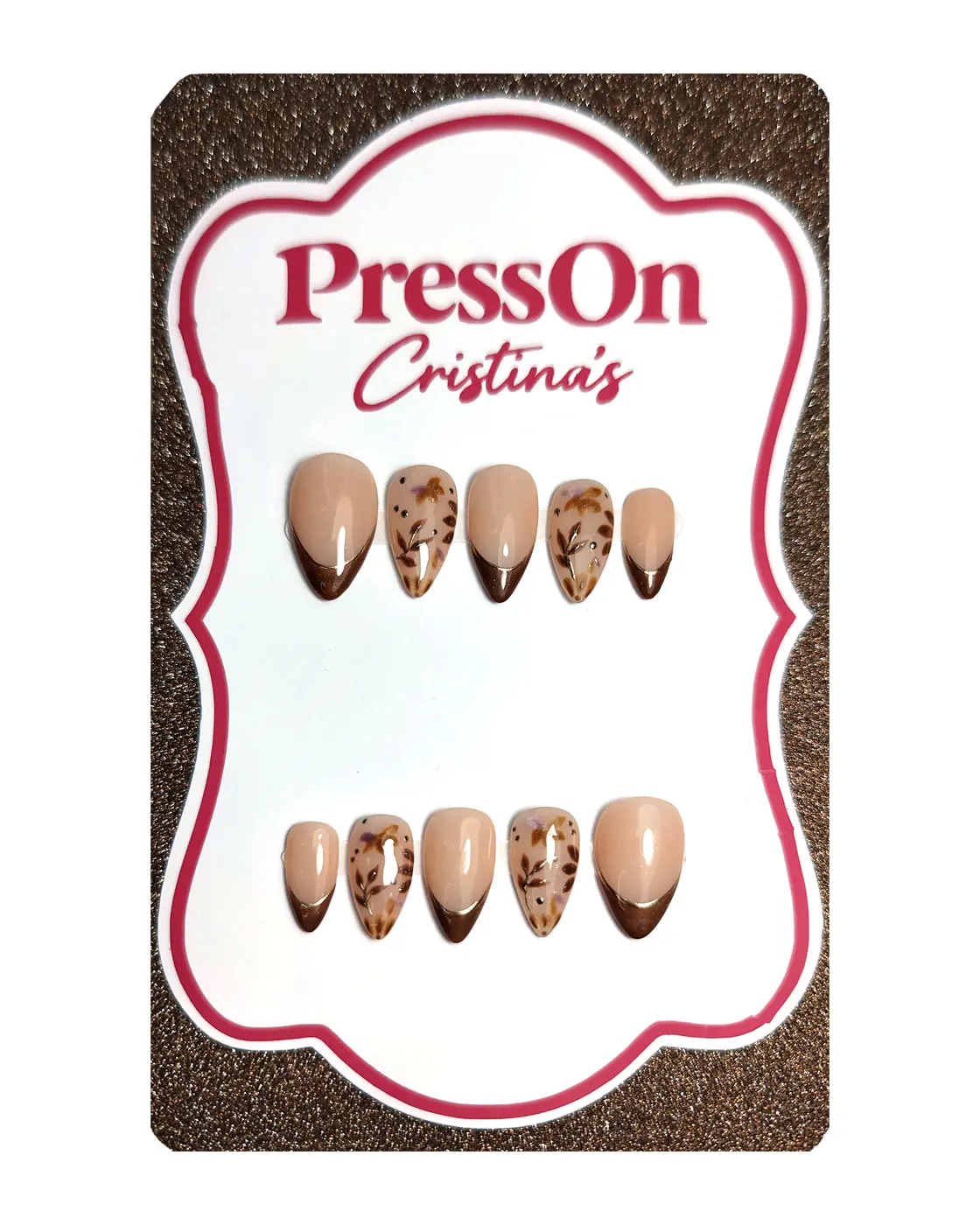 Uñas postizas almendra con francesa marrón ojo de gato y hojas otoñales pintadas a mano, sobre cartulina PressOn Cristina's, vista frontal