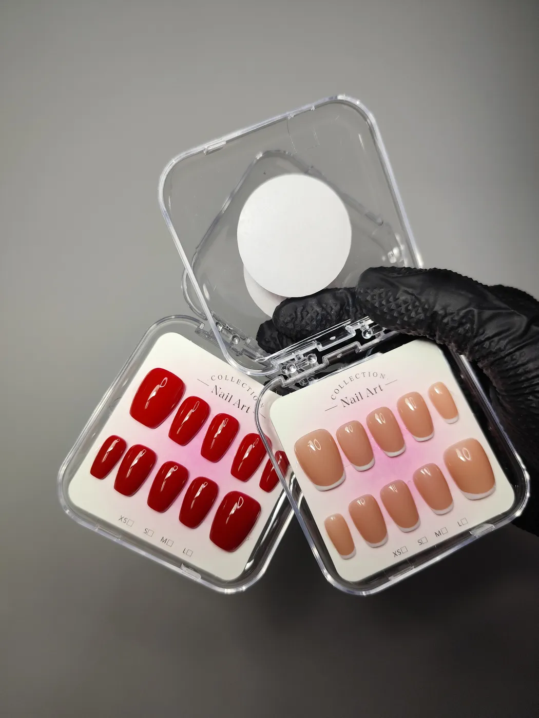 Dos estuches de uñas postizas juntos: uno con uñas coffin en rojo liso brillante y otro con uñas cortas en nude con francesa blanca