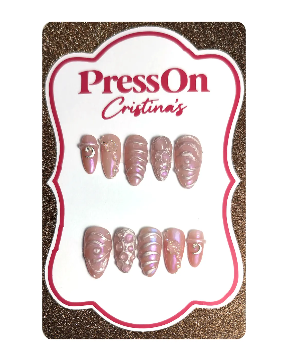 Uñas postizas almendra con relieve 3D, efecto cromado unicornio y charms de luna y rosa, sobre cartulina PressOn Cristina's, vista frontal