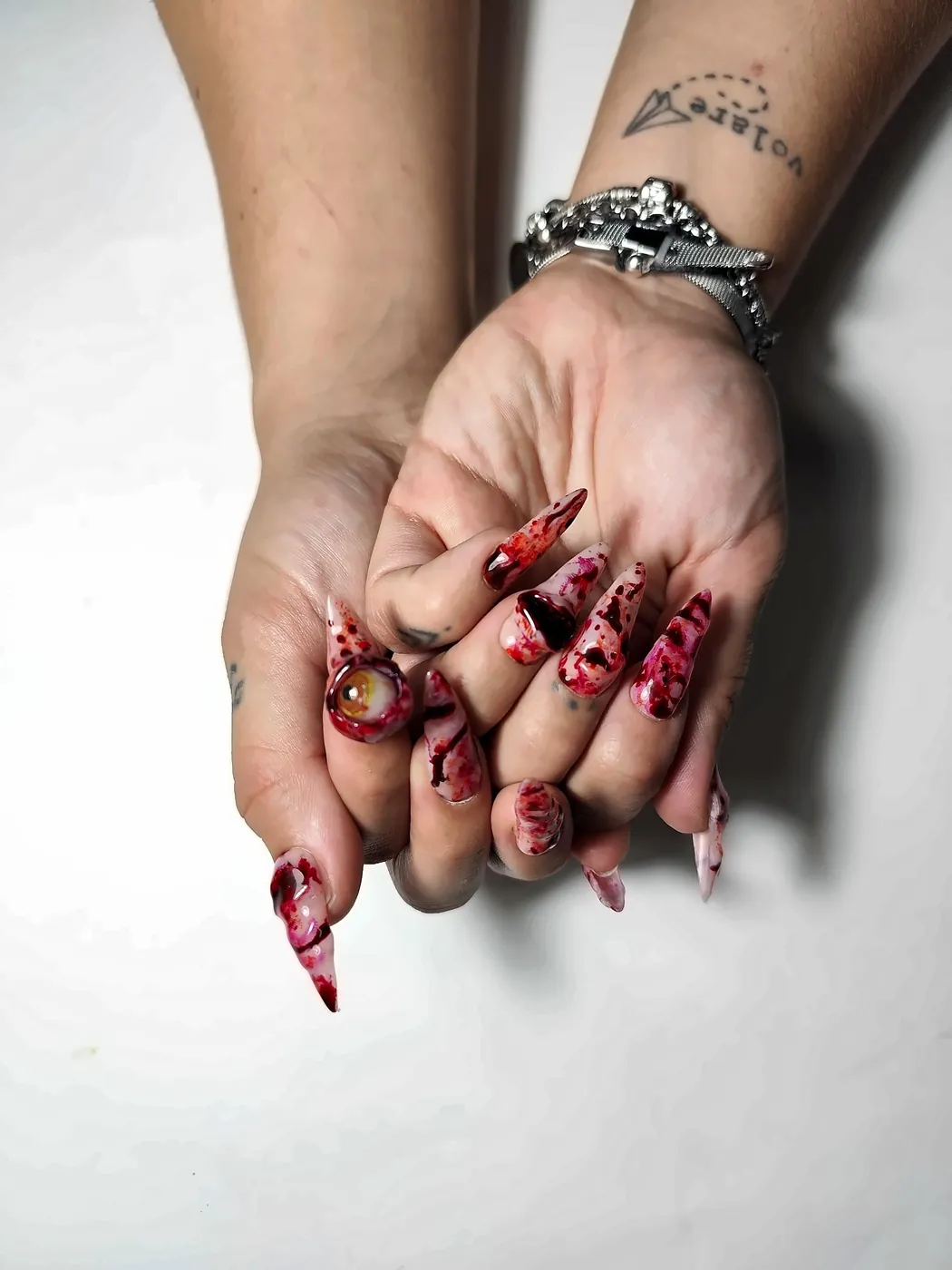 Manos con uñas postizas stiletto de Halloween con efecto sangre y heridas en relieve, vista completa