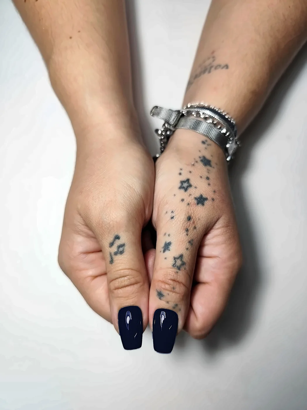 Primer plano de los pulgares con uñas postizas coffin lisas en azul noche, con acabado brillante