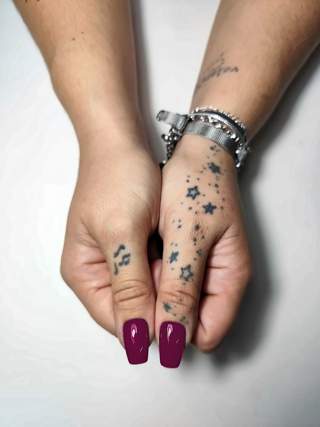 Primer plano de los pulgares con uñas postizas coffin lisas en fucsia, con acabado brillante